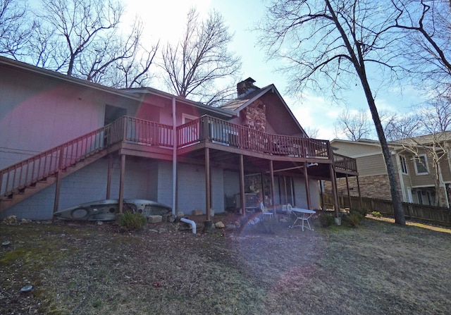 back of house featuring a chimney, stairway, fence, and a wooden deck