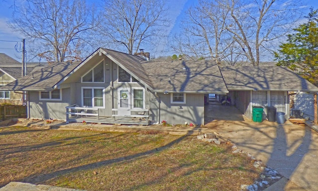 view of front of home with driveway, a chimney, and a front yard