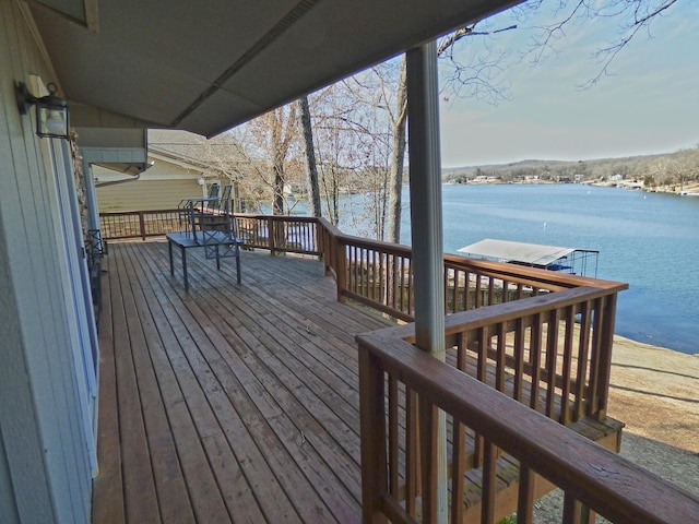 wooden terrace featuring a water view and a dock