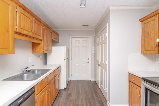 kitchen with stainless steel appliances, a sink, visible vents, light countertops, and dark wood-style floors