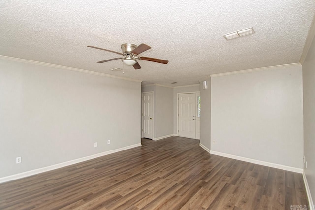 empty room featuring dark wood-style floors, visible vents, ornamental molding, and baseboards