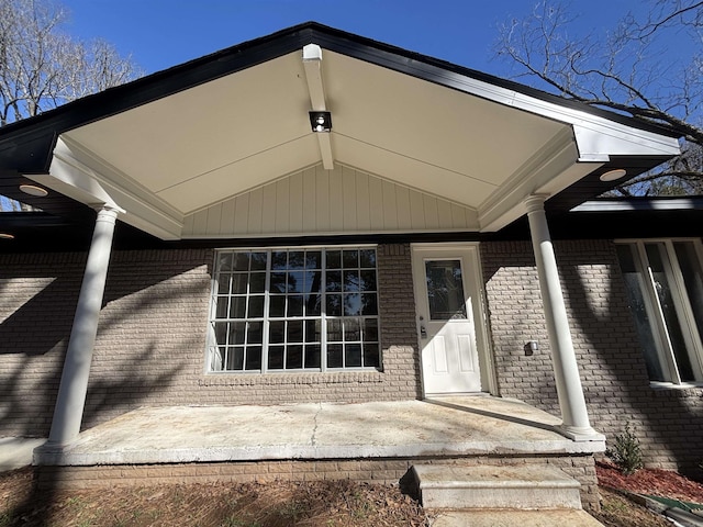 view of exterior entry with brick siding