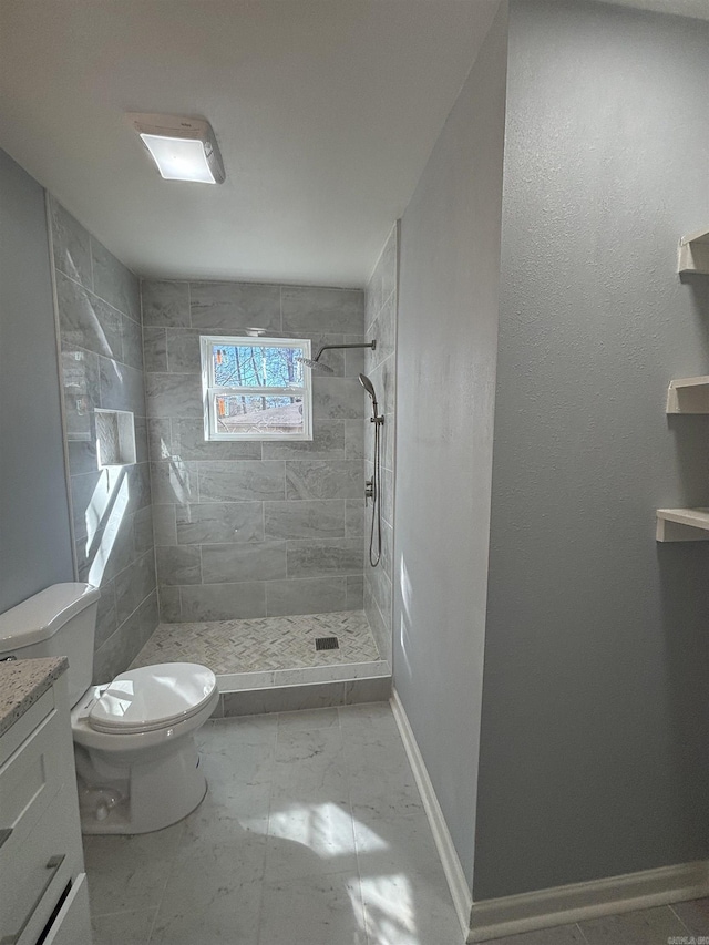 full bath featuring marble finish floor, toilet, a shower stall, vanity, and baseboards