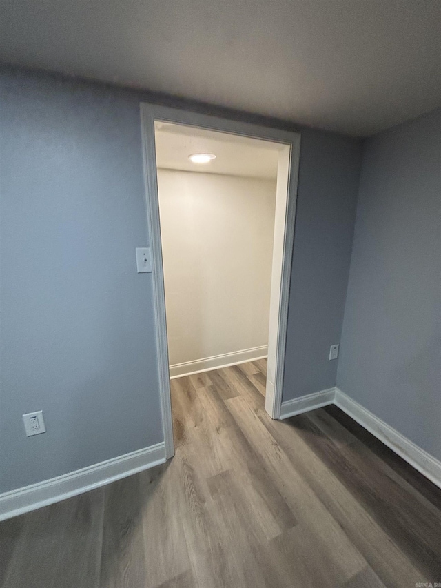 empty room with baseboards and wood finished floors