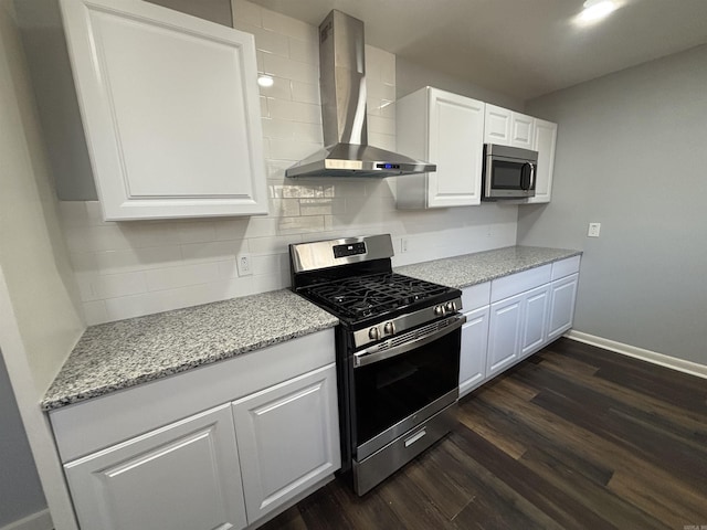 kitchen with stainless steel appliances, tasteful backsplash, dark wood-type flooring, white cabinets, and wall chimney exhaust hood