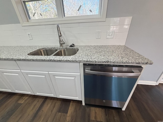 kitchen featuring dark wood-style floors, a sink, stainless steel dishwasher, and light stone countertops