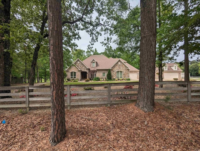 view of front of property featuring stone siding and fence