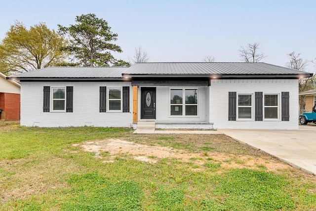 view of front of house featuring metal roof, brick siding, crawl space, and a front lawn