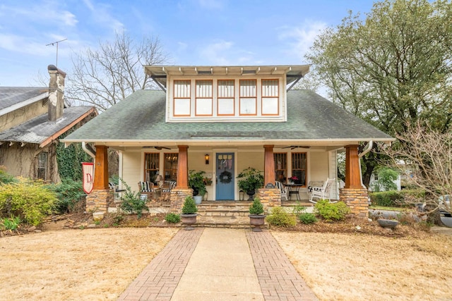 view of front of home featuring ceiling fan, a porch, and roof with shingles