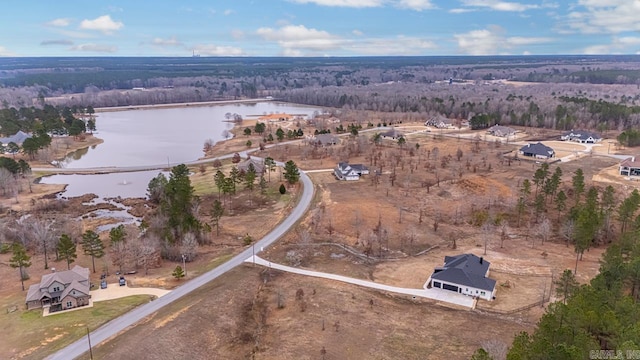 birds eye view of property with a water view and a wooded view