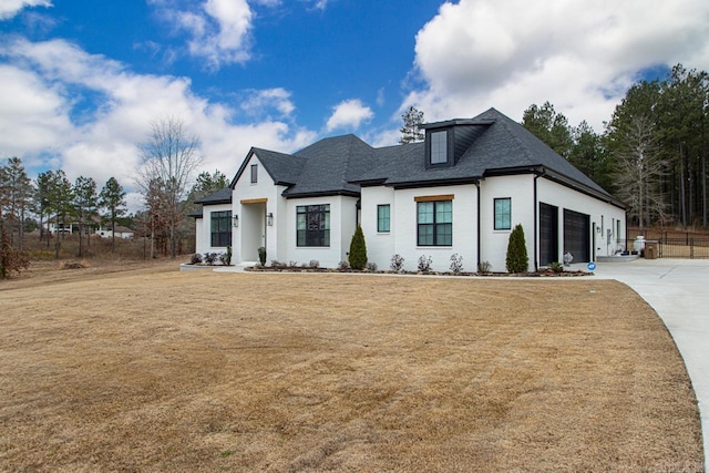 modern inspired farmhouse featuring driveway, a shingled roof, an attached garage, and a front yard