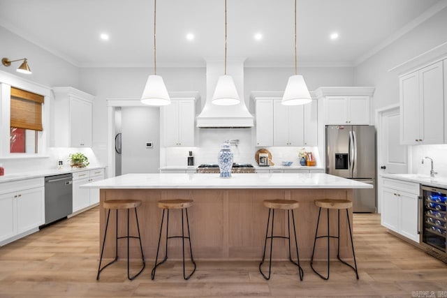 kitchen featuring beverage cooler, appliances with stainless steel finishes, white cabinets, and a large island