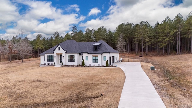 view of front of property featuring a garage, concrete driveway, and a shingled roof