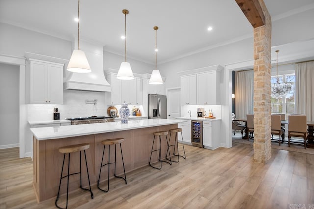 kitchen with wine cooler, stainless steel appliances, light wood-type flooring, tasteful backsplash, and custom range hood