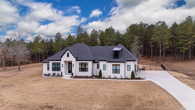 modern inspired farmhouse featuring roof with shingles