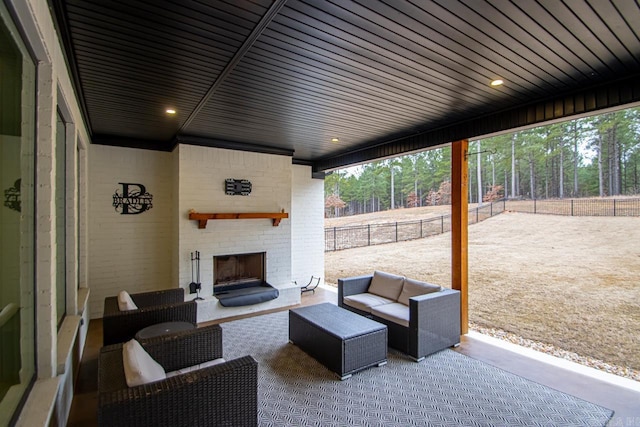 view of patio / terrace with an outdoor living space with a fireplace and fence