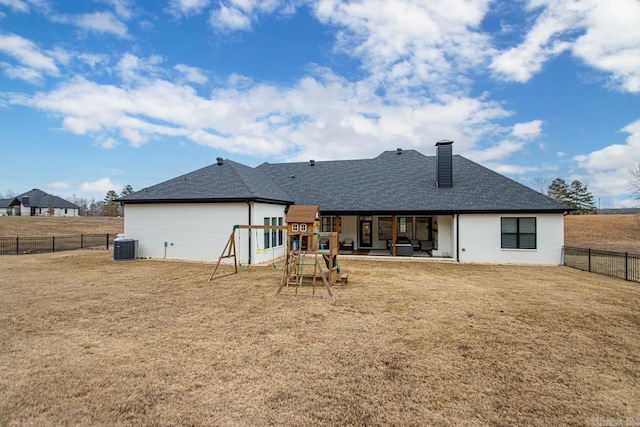 back of house with a lawn, a patio, a fenced backyard, a chimney, and central air condition unit