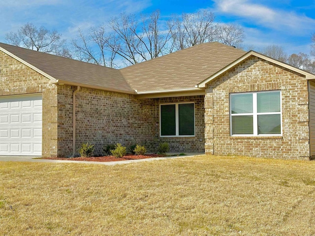 ranch-style house featuring an attached garage, brick siding, and a front yard