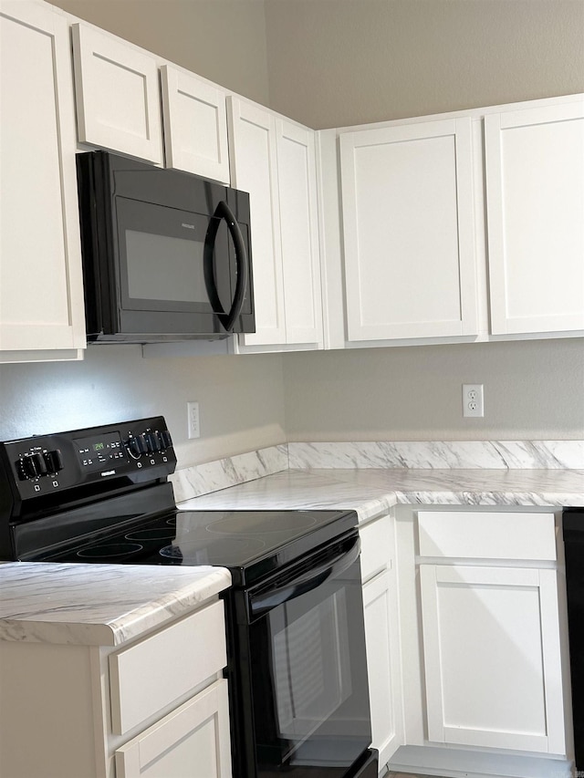 kitchen featuring black appliances, light countertops, and white cabinets