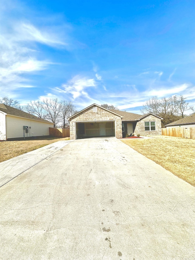 view of front facade featuring an attached garage, stone siding, fence, and concrete driveway