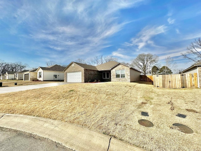 single story home featuring driveway, an attached garage, and fence