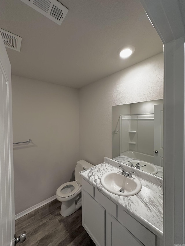 bathroom with visible vents, vanity, toilet, and wood finished floors