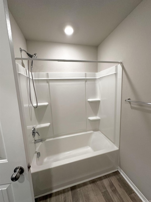 bathroom with  shower combination, wood finished floors, and baseboards