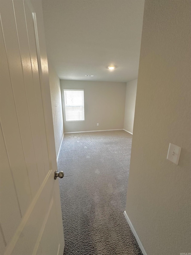 carpeted spare room with baseboards