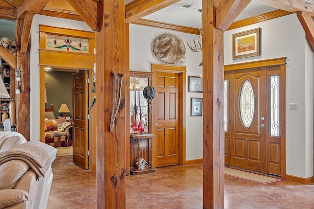 entryway featuring visible vents, ornamental molding, and baseboards