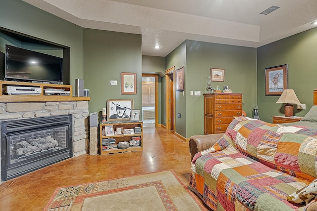 bedroom with visible vents, a stone fireplace, and baseboards