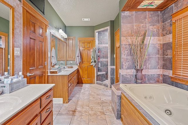 bathroom with a textured ceiling, two vanities, visible vents, a shower stall, and a tub with jets