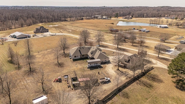 birds eye view of property featuring a water view, a forest view, and a rural view