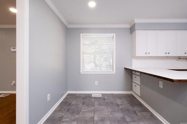 kitchen with visible vents, light countertops, white cabinetry, and crown molding