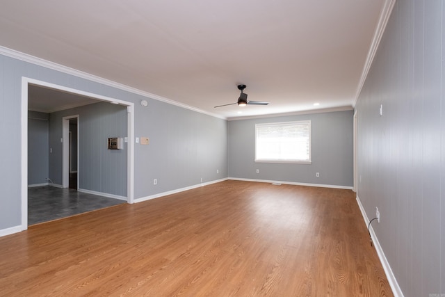 spare room featuring ornamental molding, ceiling fan, baseboards, and wood finished floors