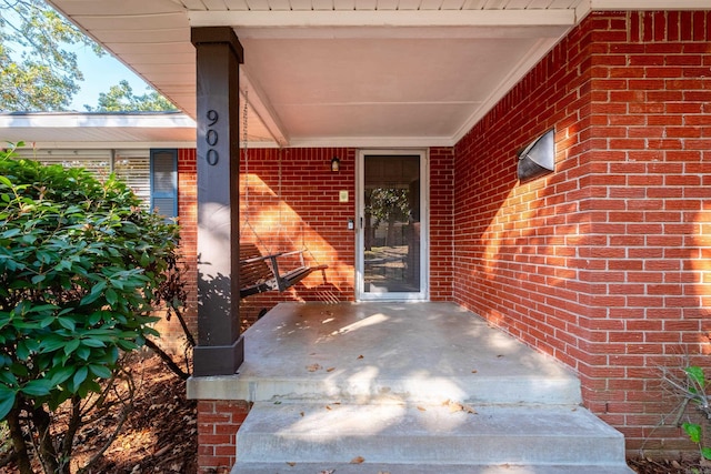 view of exterior entry featuring brick siding