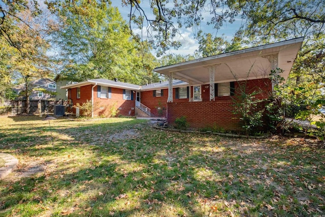 back of house with a lawn and brick siding