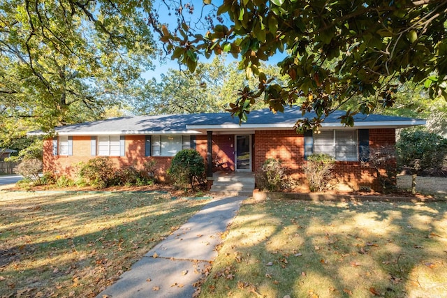 ranch-style home featuring a front yard and brick siding