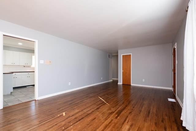 interior space with dark wood-style floors, visible vents, and baseboards