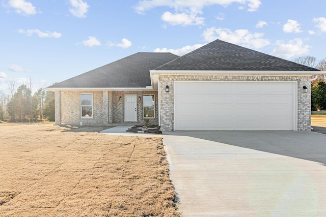 single story home featuring brick siding, a garage, driveway, and a shingled roof