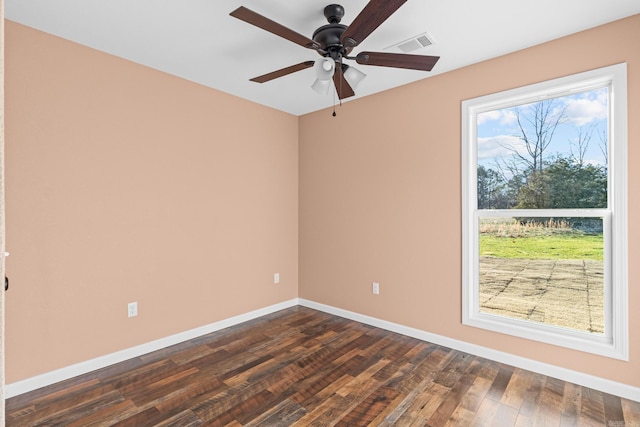 spare room featuring a ceiling fan, baseboards, visible vents, and dark wood-style flooring