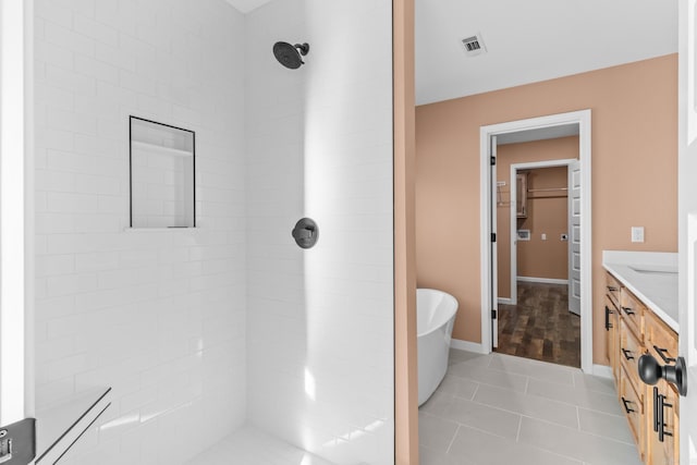 bathroom with a freestanding tub, vanity, visible vents, tiled shower, and tile patterned floors