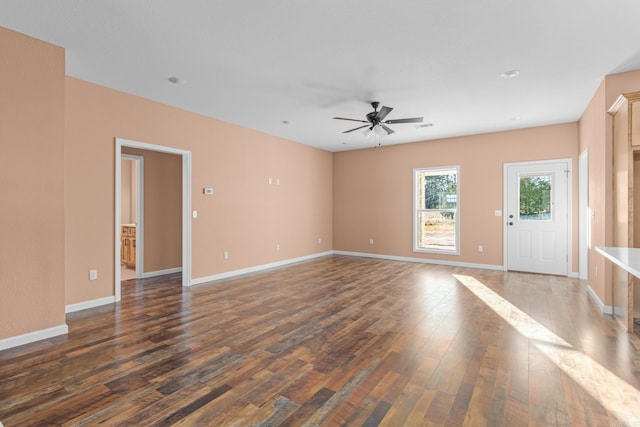 unfurnished living room featuring dark wood-style floors, baseboards, and a ceiling fan