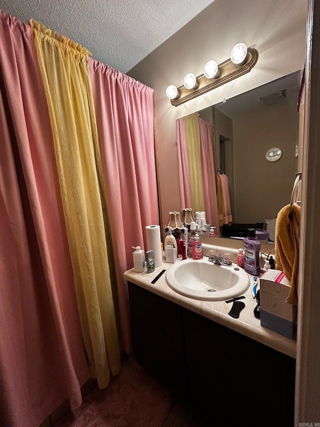 bathroom with a textured ceiling and vanity