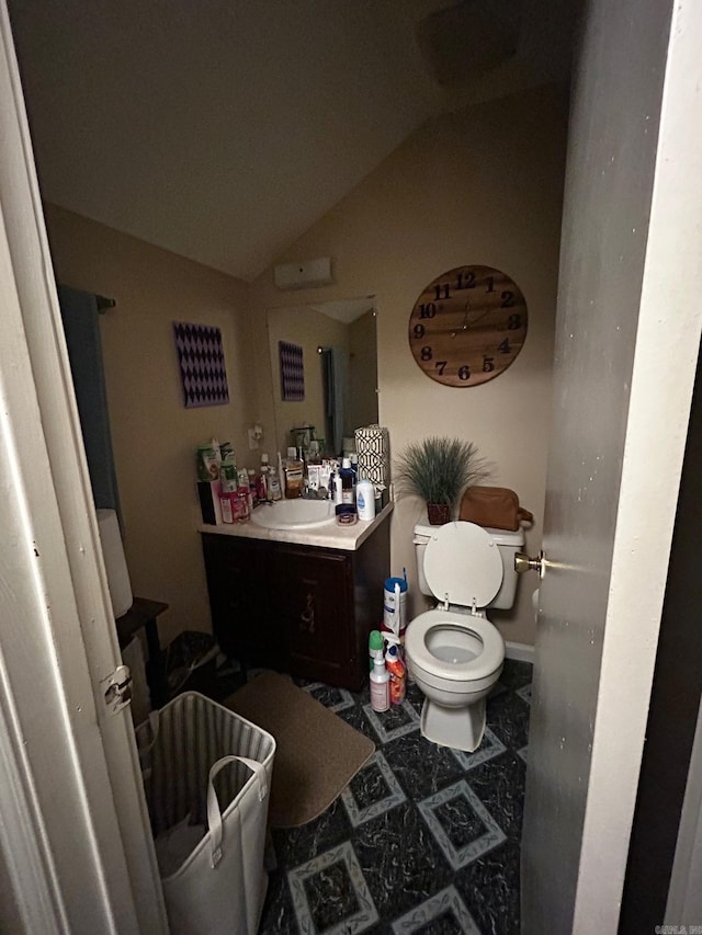 bathroom with vaulted ceiling, vanity, and toilet