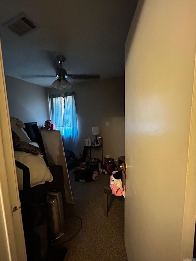 carpeted bedroom with a ceiling fan and visible vents