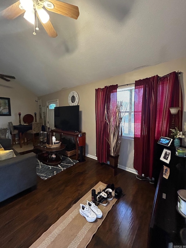 living room featuring lofted ceiling, ceiling fan, baseboards, and wood finished floors