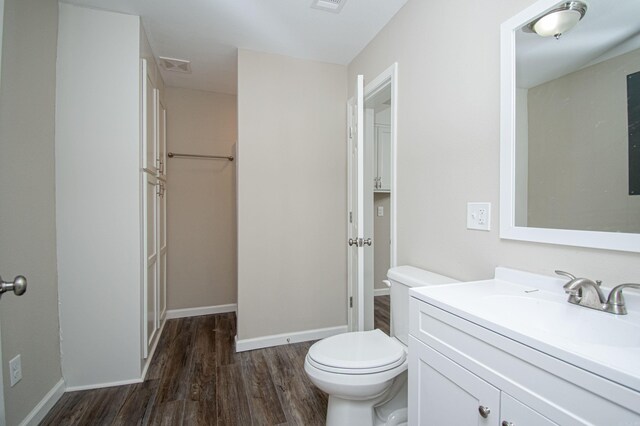 414 W Padgett Rd, El Dorado, AR 71730 - bathroom featuring visible vents, toilet, vanity, wood finished floors, and baseboards