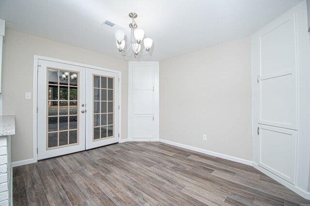 414 W Padgett Rd, El Dorado, AR 71730 - unfurnished dining area featuring baseboards, visible vents, wood finished floors, french doors, and a notable chandelier
