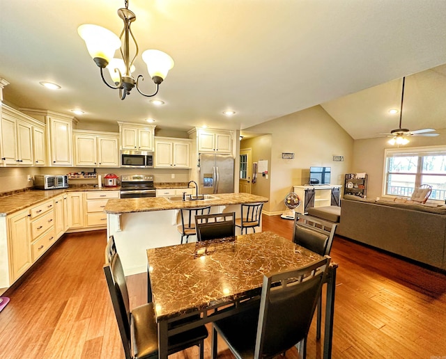 dining room featuring recessed lighting, vaulted ceiling, wood finished floors, and ceiling fan with notable chandelier