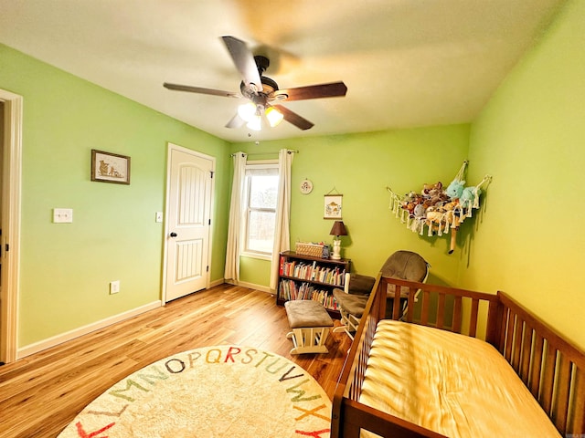 bedroom featuring a ceiling fan, baseboards, and wood finished floors